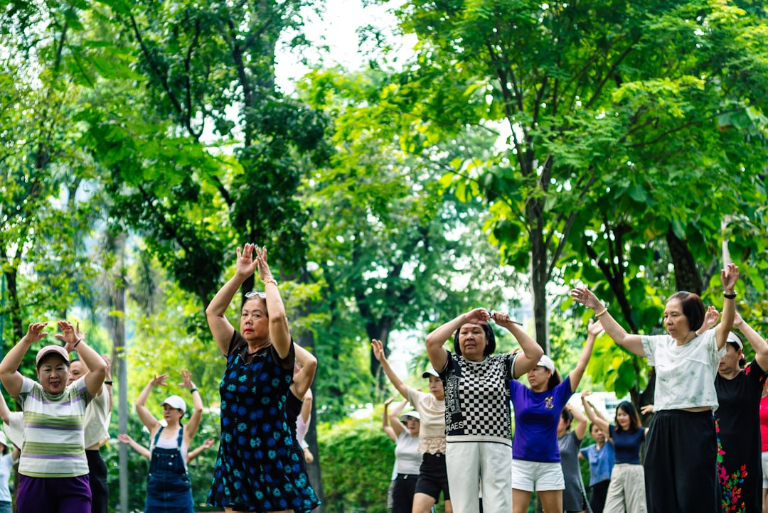 group senior citizens tai chi outdoor park morning exercise community