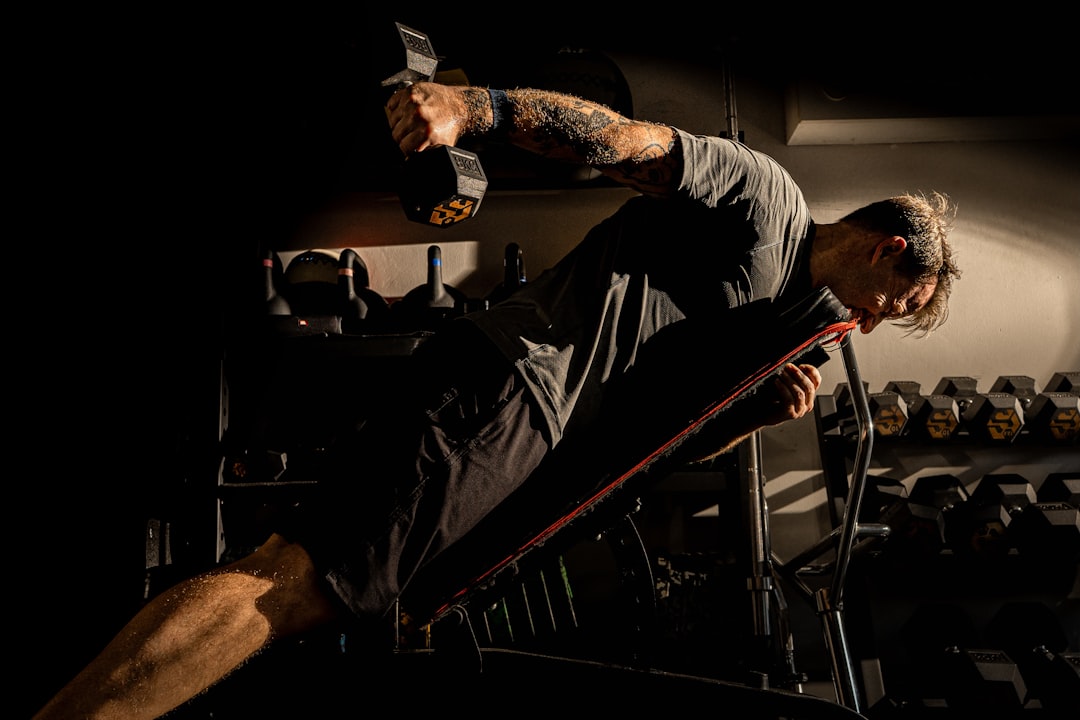 elderly man doing resistance exercise gym dumbbell