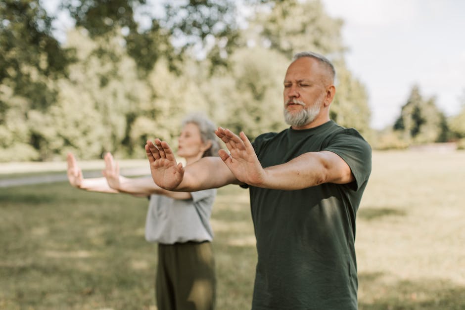 group of elderly adults doing Tai Chi in a park, senior fitness class